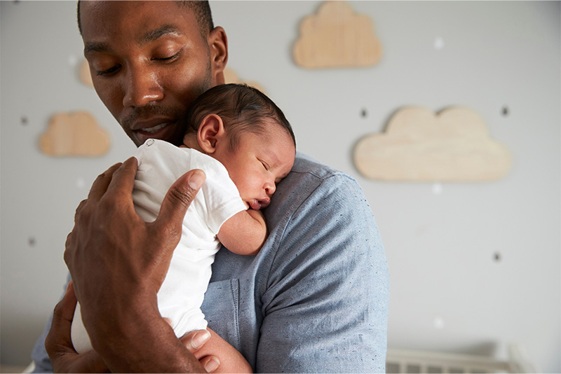 A new dad holding his baby.