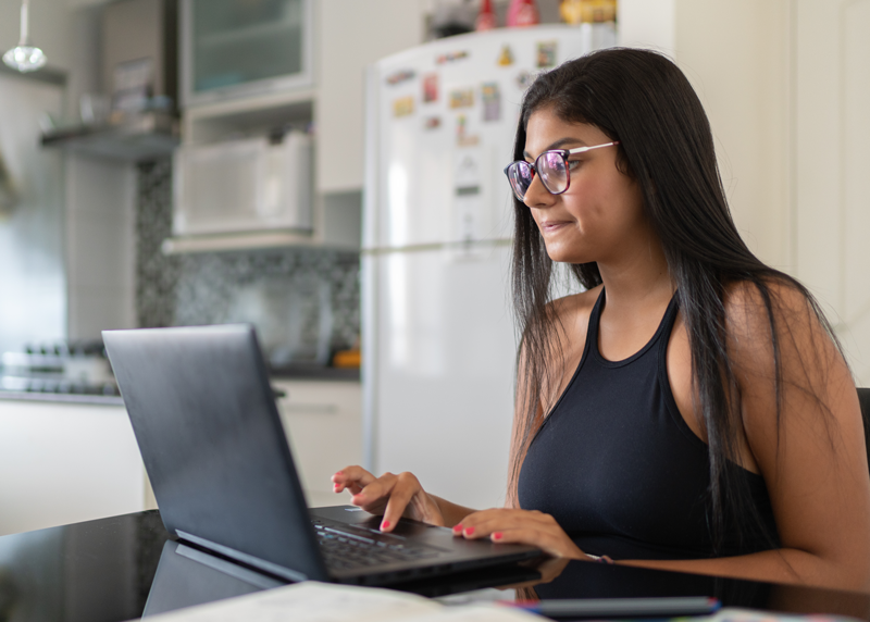 teenager working on assignments in her kitchen